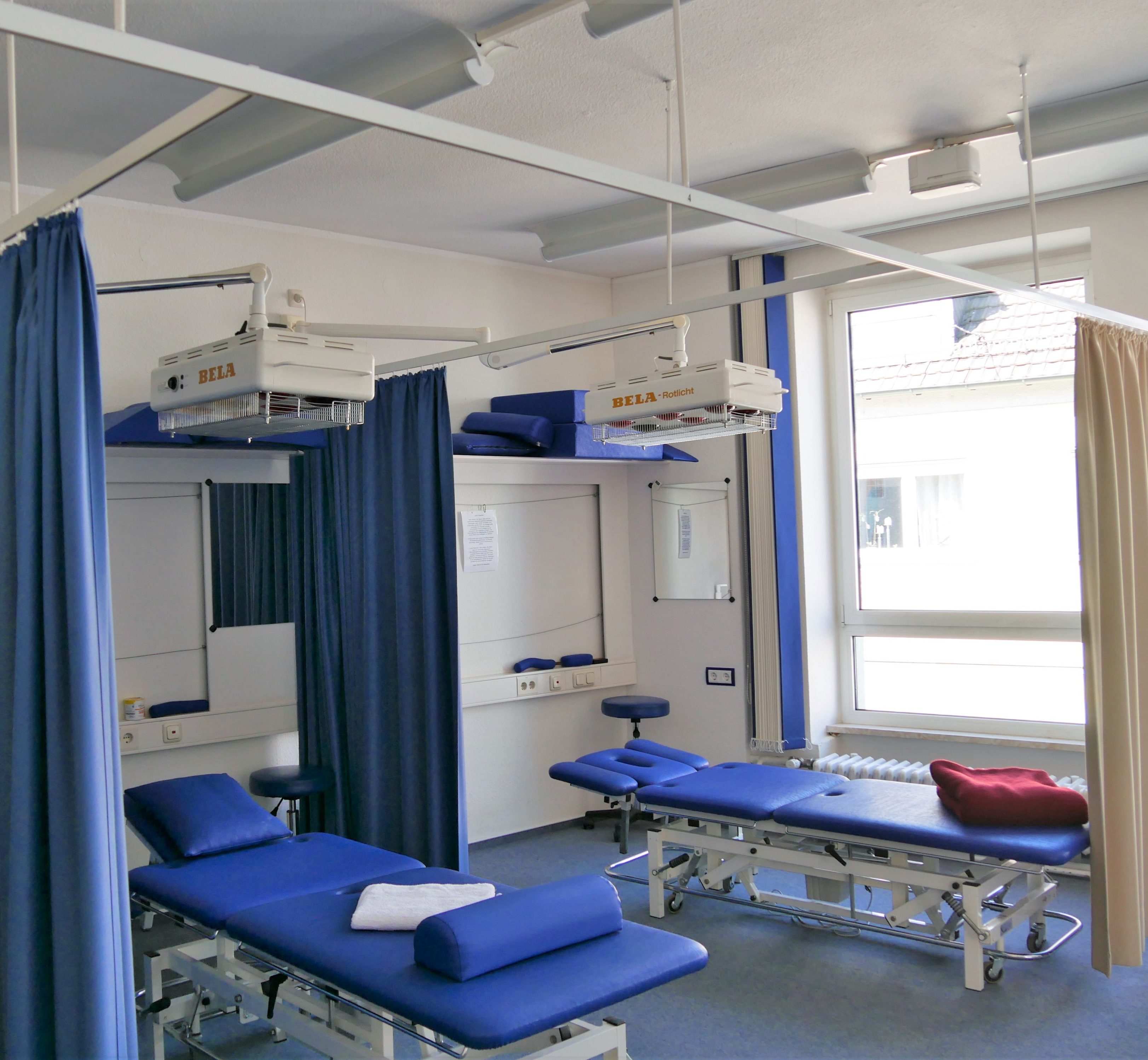 Zwei Liegen, getrennt durch Vorhänge mit Infrarot darüber.