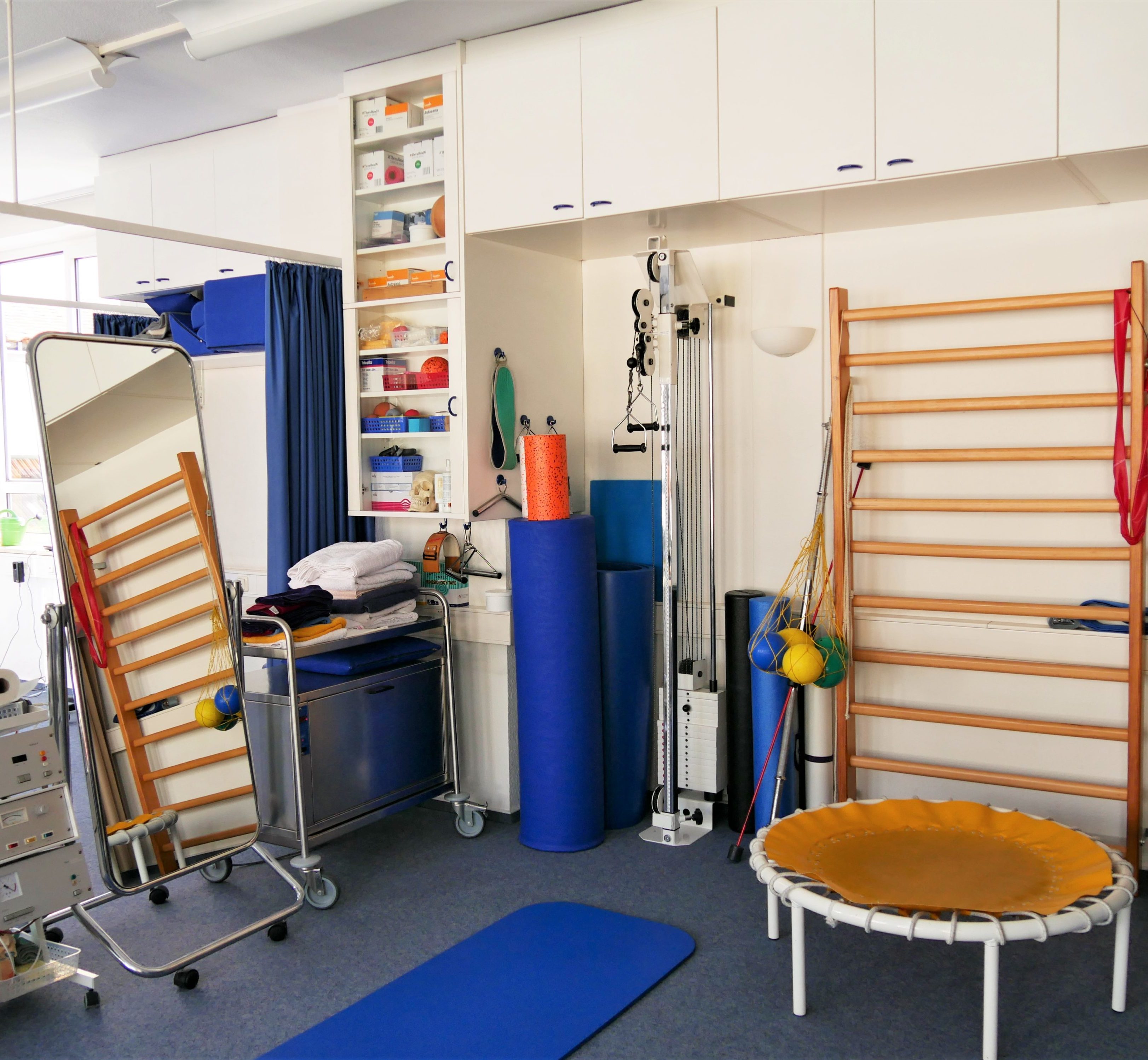 Ein Spiegel und nebendran ein Fango-Ofen, sowie eine Sportmatte, ein Trampolin und hinten ein kleines Klettergerüst.